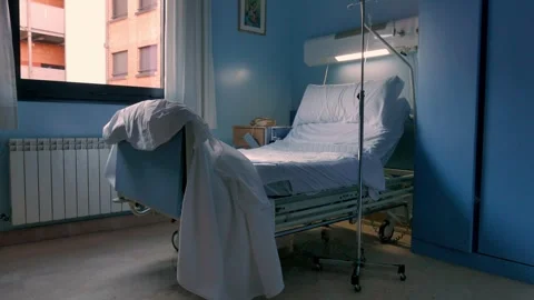 Empty Hospital Bed in a Dimly Lit Recovery Room Stock Footage 313575555