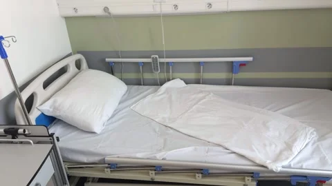 An empty hospital bed is made with white linen Vidéo 341789951