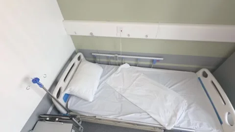 An empty hospital bed is made with white linen Видео 342102858