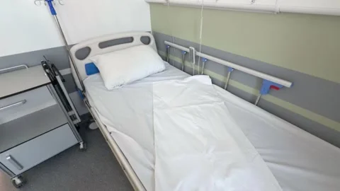 An empty hospital bed is made with white linen 스톡 동영상 342346205