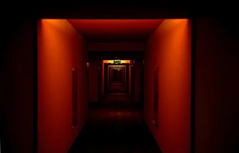 Empty hotel corridor with poor illuminated hall in red color Foto stock