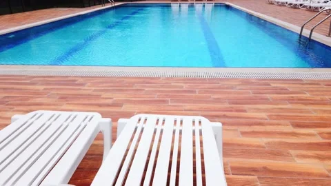 Empty hotel pool under open sky. White sunbeds without tourists, vacationers. Stock Footage 132485237