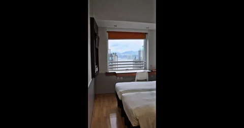 Empty hotel room with twin beds overlooking urban harbor city view Stock Footage 345268198