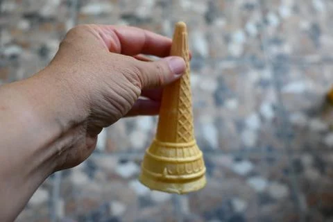 Empty ice cream cone held in hand Stockfoto's