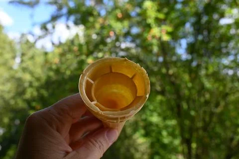 Empty ice cream cone held outdoors Photos