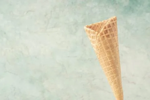 Empty ice cream cone over green background with copy space Stock Photos