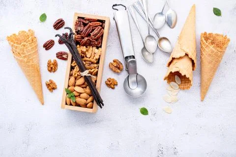 Empty  ice cream cones  with mixed nut setup on white stone background . Summ Foto stock