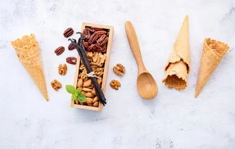 Empty  ice cream cones  with mixed nut setup on white stone background . Summ Foto stock