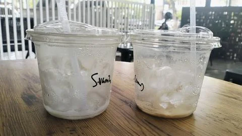 Empty Iced Coffee Takeaway Plastic Cups with Leftover Ice Cubes Stock Photos