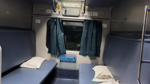 Empty indian train 3ac sleeper cabin with berths pillows and window at night Stock Footage 333907195