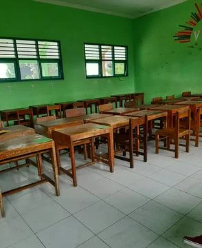 Empty Indonesian Classroom with Green Walls and Wooden Desks Stock Photos