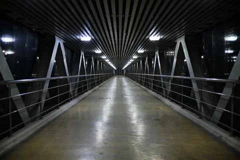 An empty indoor high-tech bridge or passage. Geometric ceiling lines and meta Stock Photos