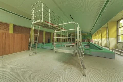 An empty indoor swimming pool with a diving platform and railings, in green, Bad Stock Photos