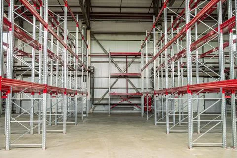 Empty industrial warehouse building with rows of racks. Warehouse passage. Stock Photos