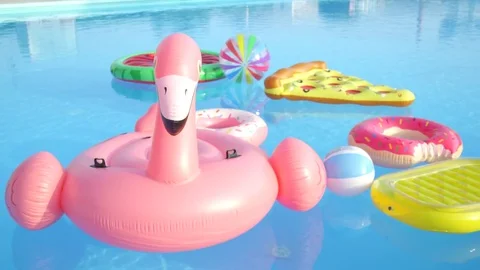 Empty inflatable flamingo, doughnuts, pineapple and watermelon floats in pool Stock Footage 78689035