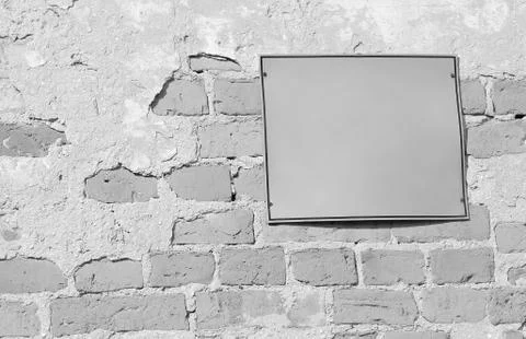 Empty information sign on old brick wall in black and white Stock Photos