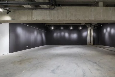 Empty interior of large concrete room as warehouse or hangar with spotlights Stock Photos