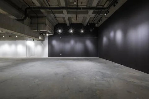 Empty interior of large concrete room as warehouse or hangar with spotlights Stock Photos