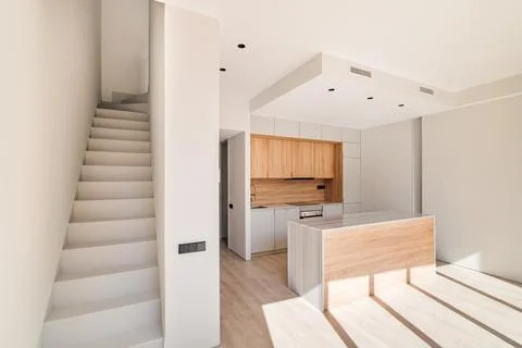Empty interior of refurbished duplex with stairs and modern kitchen with island 스톡 사진