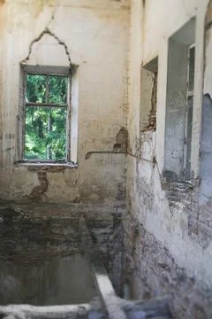 Empty interior of a ruined building with cracked brick walls and old wooden.. Foto stock
