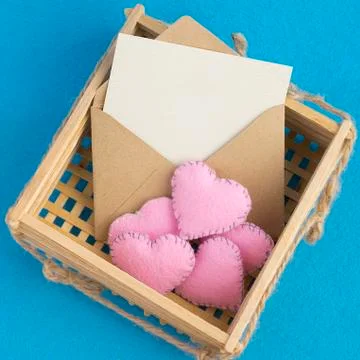 Empty invitation card. Old envelope in wooden wicker basket with plush pink Stock Photos