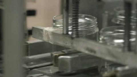 Empty jars being pushed on a production line Stock Footage 82076755