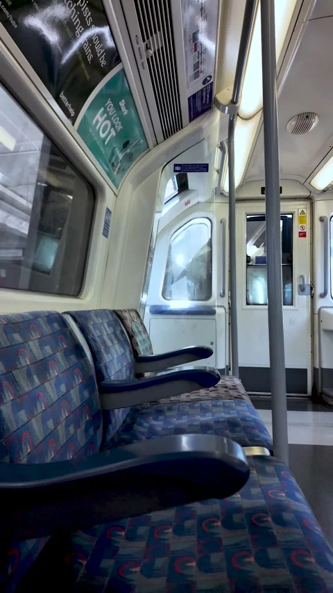 Empty Jubilee line carriage with patterned blue seats and closed doors on a Stock Footage 337873782