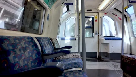 Empty Jubilee line carriage with patterned blue seats and closed doors on a Stock Footage 337874050