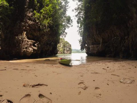 Empty kayak approached in a sandy lagoon among the rocks Stock Photos