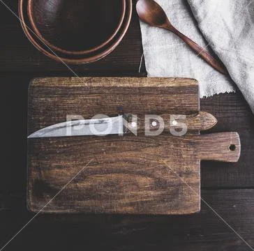 Empty kitchen brown cutting board with handle and knife Stock Photos