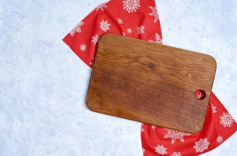 Empty kitchen cutting board with red christmas tablecloth. View from top. 库存照片