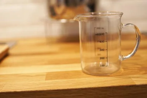 Empty kitchen measuring cup beaker isolated on blurred background Stock Photos