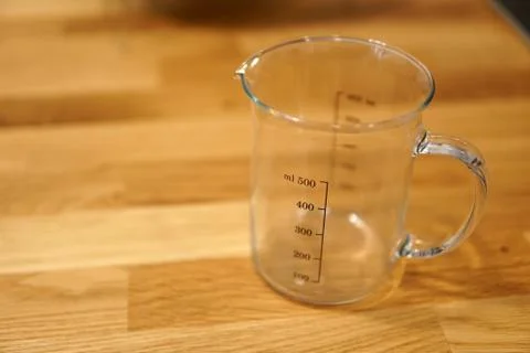 Empty kitchen measuring cup beaker isolated on blurred background Stock Photos