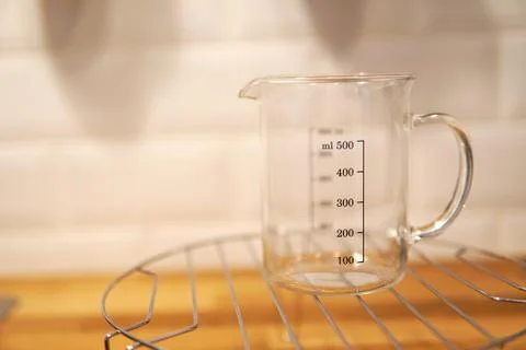 Empty kitchen measuring cup beaker isolated on blurred background Stock Photos