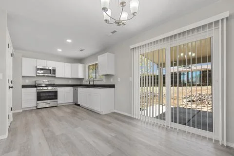 An empty kitchen with a sliding glass door and a stylish chandelier Stock Photos