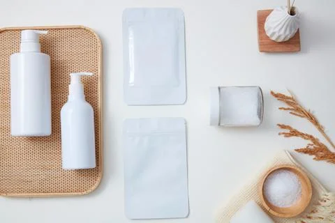 Empty label facial mask sheets, white bottles and transparent jar of scrub ar Stock Photos