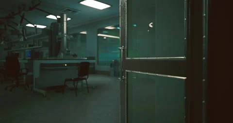 Empty laboratory with open door at night revealing dim workspace and chairs Vidéo 310659017