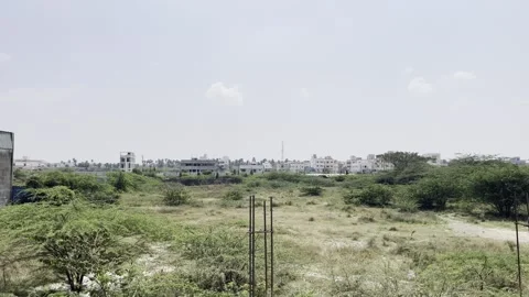An empty land filled with trees and plants near the urban area Stock Footage 312320637
