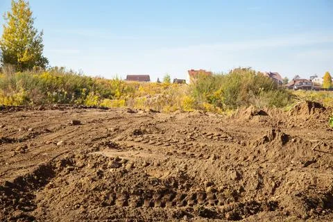 Empty land plot with tire prints prepared for new housing in rural area Stock Photos