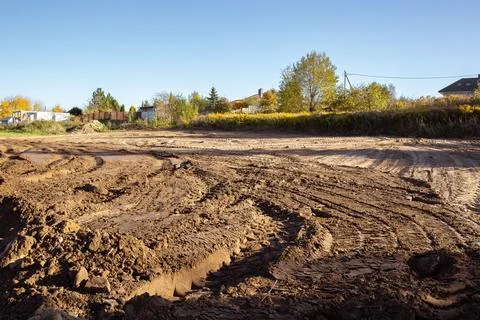 Empty land plot with tire prints prepared for new housing in rural area Stock Photos