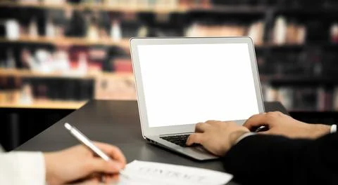 Empty laptop computer screen for astute design mockup on a table in library Stock Photos