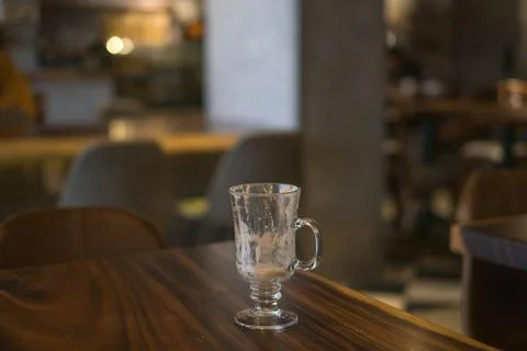 Empty latte glass cup on the table in coffee shop. Stock Photos