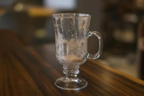 Empty latte glass cup on the table in coffee shop. Stock Photos