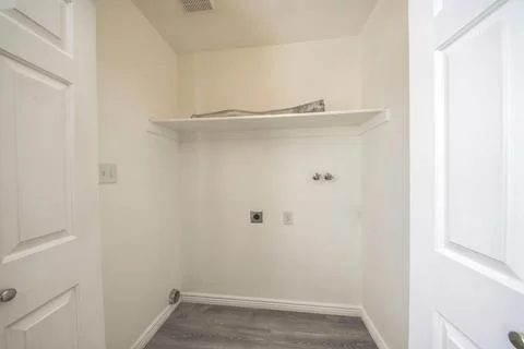Empty laundry room interior with electrical socket and wall mounted faucet Stock Photos