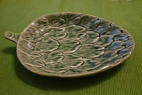 Empty leaf-shaped decorative plate on green fabric Stock Photos