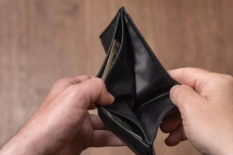 Empty leather wallet in the hands of a man, close-up. Poverty concept Stock Photos