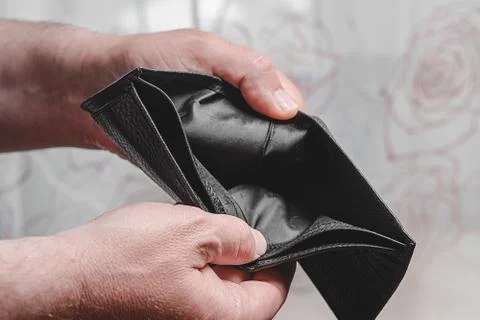 Empty leather wallet in the hands of a man, close-up. Poverty concept Stock Photos