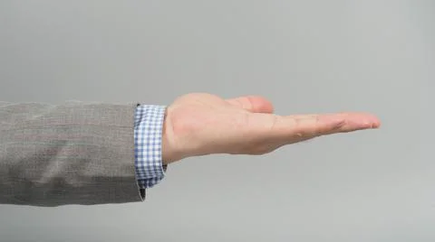 Empty Left Hand gesture in grey suit on grey background. Businessman topic Stock Photos