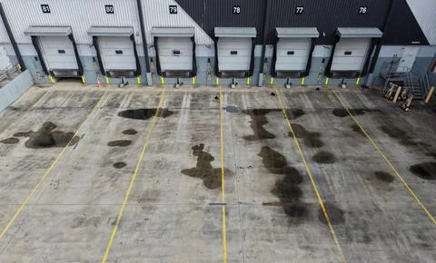 Empty loading dock doors with puddles on concrete Fotos de archivo