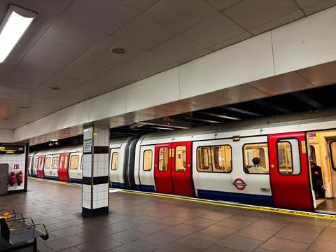 Empty London Underground platform with red and white train and commuters bo.. Stock Photos